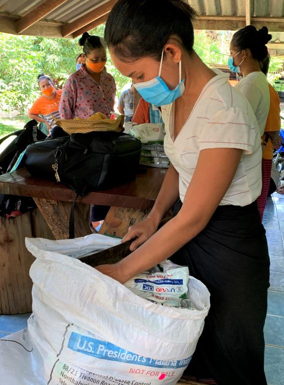 A village health volunteer is preparing insecticide-treated nets donated by PMI to be distributed to the villagers in Sangklaburi district.  A joint field visit with the Division of Vector Borne Diseases (DVBD) and local health office  July 20, 2020  Kanchanaburi, Thailand  Photo by Niparueradee Pinyajeerapat, USAID