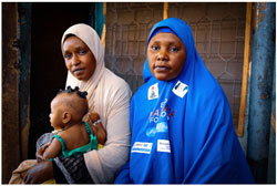 Two women siting down and a child sitting on one woman's lap